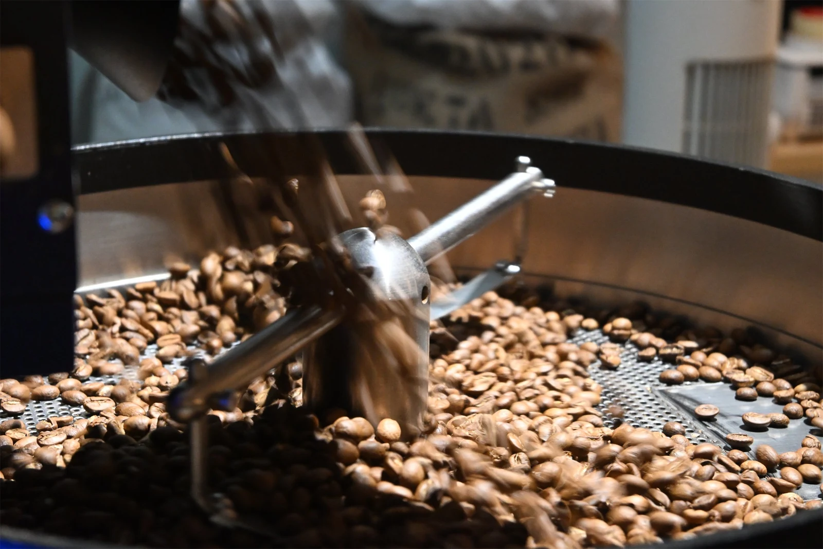 Fresh coffee beans moving through the cooling tray after roasting
